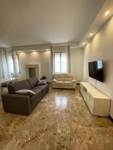 a living room with a couch and a flat screen tv at The modern House in Mantova