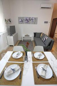 Una sala de estar con una mesa con platos y sillas. en Appartamento San Donato, en Florencia