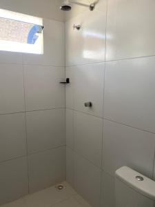 Un baño blanco con inodoro y ventana. en Temporada BHS Quarto 4, en Barreirinhas
