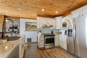 a kitchen with white cabinets and a stainless steel refrigerator at Wishlist in Beech Mountain
