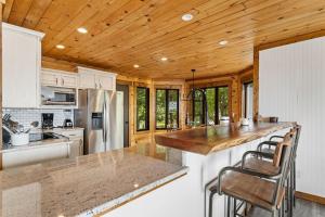 a kitchen with white cabinets and a wooden ceiling at Wishlist in Beech Mountain +30 photos