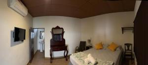 a bedroom with a bed and a mirror and a sink at Hostal DEYLUWIN in Juayúa