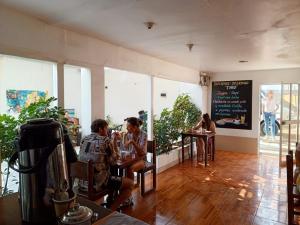 two people sitting at a table in a restaurant at Hostel Willys House in Paracas +62 photos