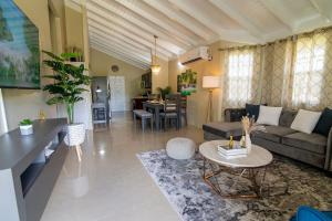 曼米湾Drax Hall-Near Ocho Rios-King Bed-Pool-BBQ Grill-Gated Complex-Free Parking-Free Wifi 100Mbps的带沙发和桌子的客厅