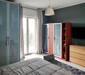 sypialnia z łóżkiem, komodą i telewizorem w obiekcie Antonio's BnB w mieście Casalnuovo di Napoli