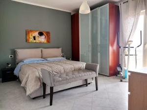 sypialnia z łóżkiem i ławką w obiekcie Antonio's BnB w mieście Casalnuovo di Napoli