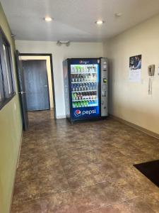 a soda machine in the corner of a room at Super 8 by Wyndham Nebraska City in Percival