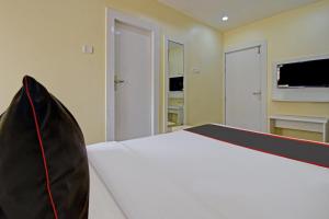 a bedroom with a white bed and a tv at Collection O Ketan Regency Near Acropolis Mall in Kolkata