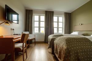 a hotel room with two beds and a desk at Gistihúsið - Lake Hotel Egilsstadir in Egilsstadir