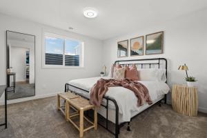 a bedroom with a large bed and a table at Livingston Way I Sleep 6 I Netflix I Kitchen I TV in Pincher Creek