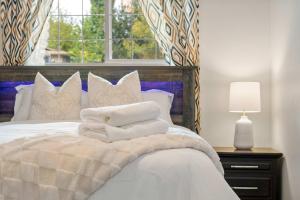 a bedroom with a bed with white pillows and a window at 2BR Cozy Suite w Fireplace! FREE Banff Pass, Parking, Netflix! Enjoy Yoga Classes or Plan Your Golf Trip! in Calgary