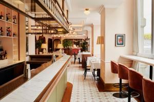 a restaurant with a bar and some tables and chairs at Hyde London City - St Paul's in London
