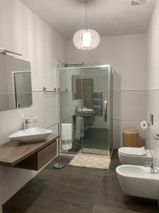 un bagno con due lavandini e una doccia in vetro di Wellhouse a SantʼAntìoco