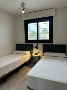 two beds in a room with a window at The Aire Residencial by Mar Holidays in Orihuela +35 photos