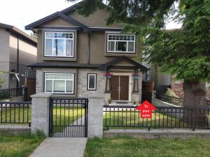 a house with a gate with a sale sign on it at Private Suite w King Bed, Ground Level, Naturally Bright in Vancouver