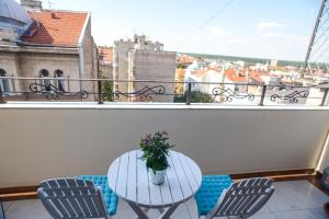 a table and chairs on a balcony with a view at Apartments Belvedere in Belgrade