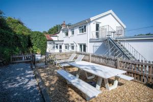 a picnic table in front of a white house at Bryn View – 5 Bedroom Holiday Home – Oxwich in Oxwich
