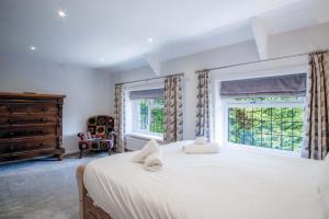 a bedroom with a large white bed and a window at Bryn View – 5 Bedroom Holiday Home – Oxwich in Oxwich