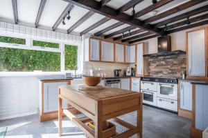 a kitchen with white appliances and a wooden table at Bryn View – 5 Bedroom Holiday Home – Oxwich in Oxwich