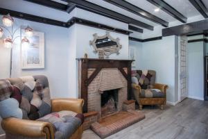 a living room with two couches and a fireplace at Bryn View – 5 Bedroom Holiday Home – Oxwich in Oxwich