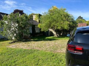 ein vor einem Haus geparktes Auto in der Unterkunft Maison de campagne familiale in LʼHabit