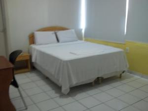 a bedroom with a bed with white sheets and pillows at Opara Palace Hotel in Juazeiro