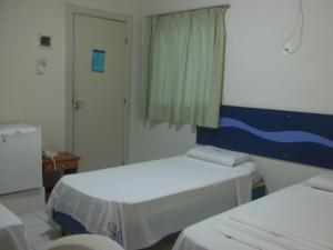 a hospital room with two beds and a window at Opara Palace Hotel in Juazeiro