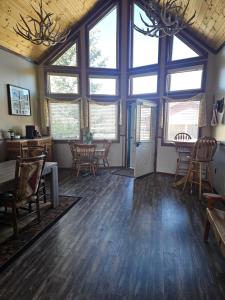 a living room with large windows and wooden floors at Salt River Lodge in Thayne