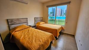 a bedroom with two beds and a large window at Dreams Lagoon in Cancún