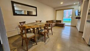 a dining room with a table and chairs and a couch at Dreams Lagoon in Cancún