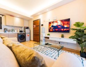 ein Wohnzimmer mit einer Couch und einem Fernseher an der Wand in der Unterkunft Elite Residences by Bednbeyond O72195O3I9 in Nairobi