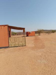 een gebouw midden in een woestijn met een doel bij Petrified forest restcamp in Khorixas +3 foto's