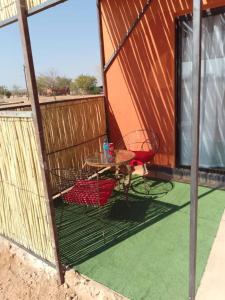 een patio met een tafel en stoelen in een gebouw bij Petrified forest restcamp in Khorixas