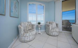 a living room with two chairs and a table at FL-Beach Colony East E3B condo in Pensacola