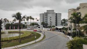 a street in a city with palm trees and buildings at Apartamento Largo dos Coqueiros in Riviera de São Lourenço