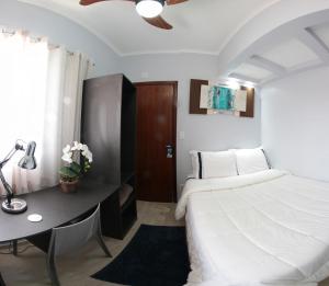 a bedroom with a bed and a desk and a bed at Santo Antônio Hotel Ltda in Angatuba