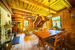 a wooden dining room with a table and a fireplace at Wapienne domek in Sękowa +79 photos