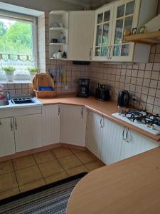 a kitchen with white cabinets and a counter top at DOM NAD JEZIOREM KUŹNIa in Łąkie