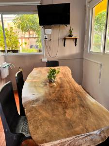 a wooden table in a room with chairs and a tv at Casa Manglares Capurganá in Acanti