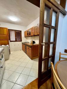 a large kitchen with wooden cabinets and a table at Harmonija - Trn, Banjaluka in Laktaši