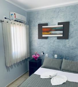 una camera da letto con un letto e una TV a parete di Santo Antônio Hotel Ltda ad Angatuba