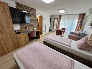 a hotel room with two beds and a flat screen tv at Apartment "Amalia" mit Klima, überdachter Terrasse & Parkplatz in Ergersheim
