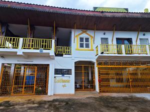 Edificio blanco con puertas amarillas y balcón en Gold house apartment 2, en Vientiane