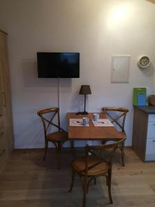 a room with a table and chairs and a television at Ferienwohnung Ostermair Apartment Gudiberg in Garmisch-Partenkirchen