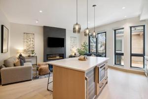 an open kitchen and living room with a couch at One Riverfront Condo 108 by East West Hospitality in Avon