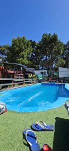 una piscina con un par de sandalias en el césped en Casa de Campo La Maribel, en La Lucila del Mar