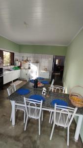 a kitchen with a table with white chairs and a counter at Casa Bem te Vi - Cavalcante in Cavalcante +12 photos
