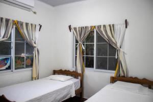 two beds in a room with two windows at Villas Julie in Tela +20 photos