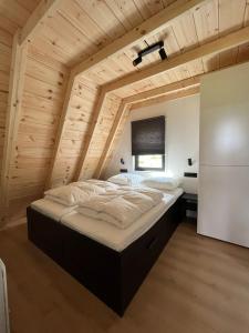 ein großes Bett in einem Zimmer mit Holzdecke in der Unterkunft S t e e n b o k - Luxe Alpenhuis in prachtig Karinthië in Gnesau Sonnleiten + 2 Fotos