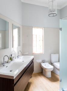 Baño blanco con lavabo y aseo en 22 Van Wijk Street Tourist Accommodation en Franschhoek
